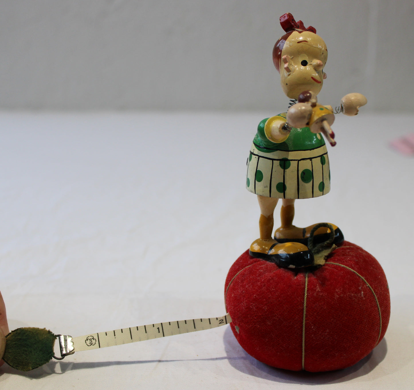 Lovely vintage pin cushion with wooden wobbly headed doll and integrated tape measure